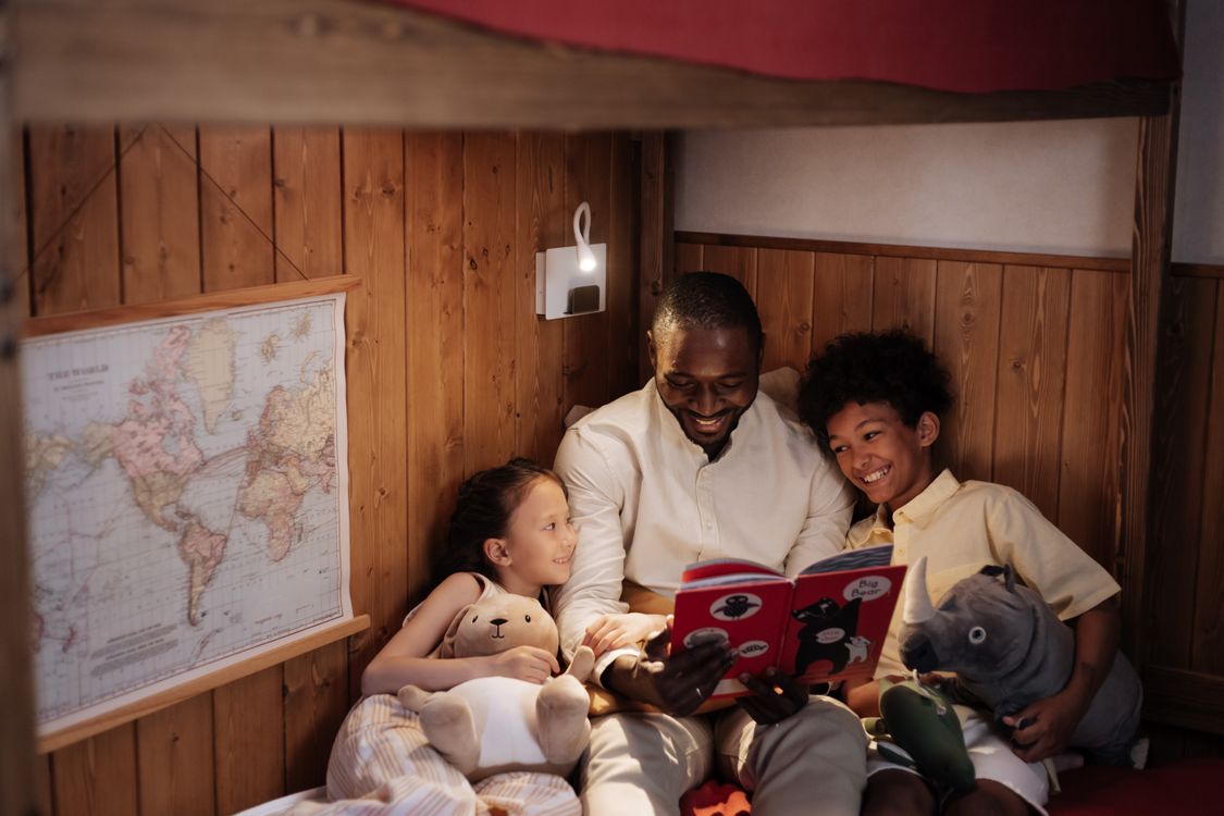 A father sharing a storybook with his children